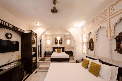 a bedroom with a bed and a tv in a room at Hotel Pearl Palace in Jaipur