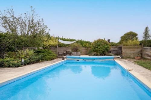 une grande piscine bleue dans une cour dans l'établissement Villa Migron - Charmante maison avec piscine, à Migron