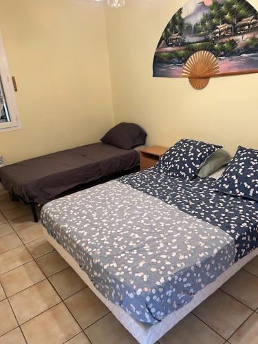 une chambre avec deux lits et un tableau au mur dans l'établissement Belle villa de 90m2 au calme avec jardin et parking à 10 mn de la mer en voiture, à Fos-sur-Mer