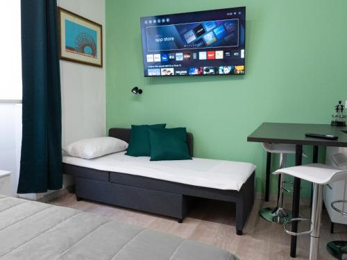 a room with a bed with a tv on the wall at Porta Vittoria Residence in Milan