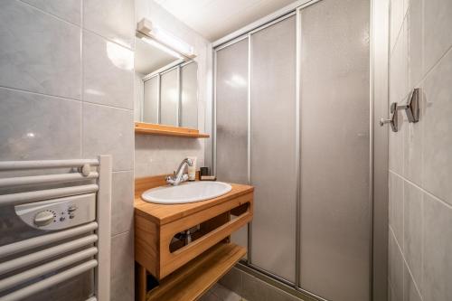 een badkamer met een wastafel en een douche bij Chalet La Grangerie in Montriond