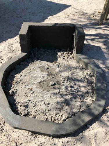 a large concrete hole in the ground in the sand at Moae Campsite 