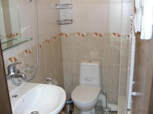 een badkamer met een wit toilet en een wastafel bij Villa Persenk in Lyaskovo