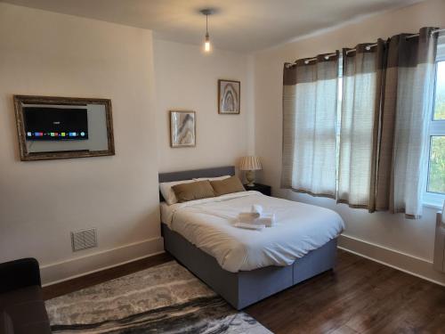 a bedroom with a large bed and a window at 1 Bed Flat - Sleeps 3 - Parking - Wifi in Greenhithe