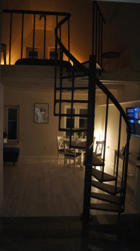 a living room with a spiral staircase in the dark at Apartamenty Street 18 in Toruń