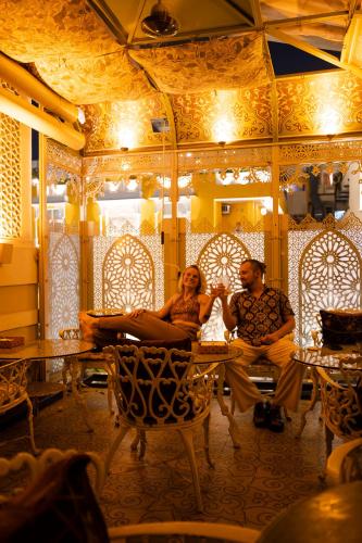 a man and a woman sitting at a table in a room at Hotel Pearl Palace Jaipur in Jaipur