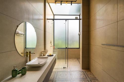 y baño con lavabo y espejo. en StayVista's Anantam - Villa with Massive Outdoor Pool with Deck & Sprawling Lawn en Nueva Delhi