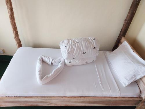 Hill View Garden Hotel في موشي: سرير مع وسادتين على شكل قلب