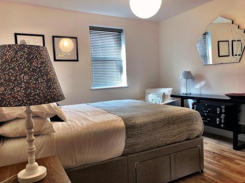una camera da letto con un letto con una lampada e una scrivania di Crown House is a brand new development with unique features a Newbury
