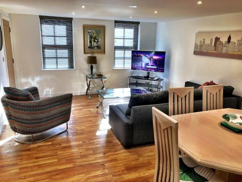 sala de estar con sofás, mesa y TV en Crown House is a brand new development with unique features en Newbury