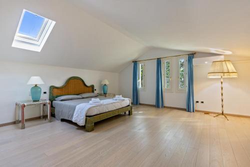 um quarto com uma cama e um candeeiro num piso de madeira em Villa Magnolia em Arcugnano