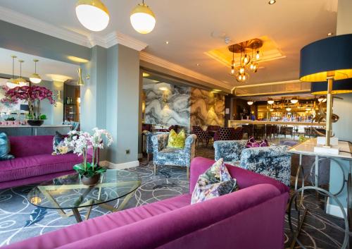 eine Lobby mit lila Sofas und einer Bar in der Unterkunft Hotel Sheraton in Blackpool