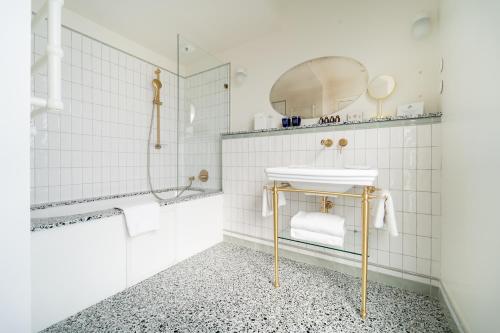 a white bathroom with a sink and a mirror at Hôtel Monte Cristo in Paris
