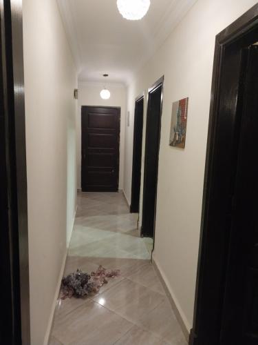 um corredor com uma porta e um piso de azulejo em الرحاب . دار مصر القرنفل . القاهرة الجديدة 