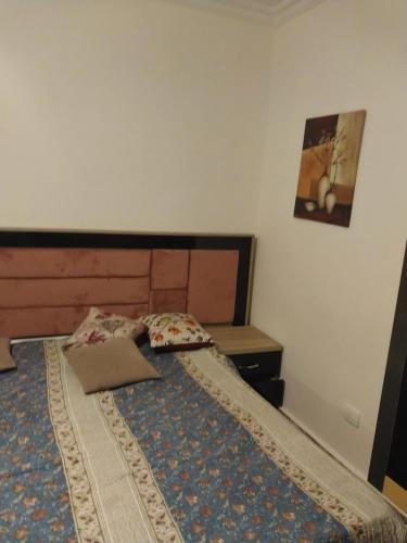 um quarto com uma cama com uma cabeceira de madeira em الرحاب . دار مصر القرنفل . القاهرة الجديدة 