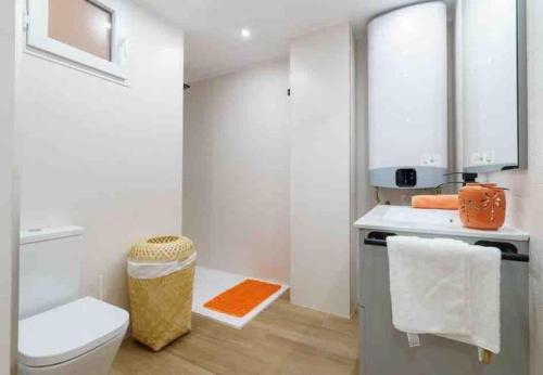 een witte badkamer met een toilet en een wastafel bij Bonito apartamento a pocos minutos del centro CLAV- in Málaga