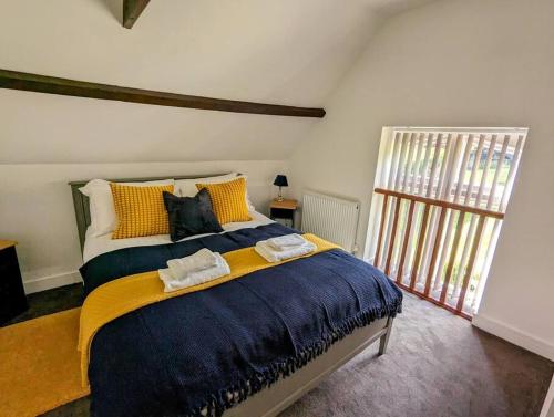 a bedroom with a large bed with two towels on it at The Snug at Cefn Tilla Court in Usk