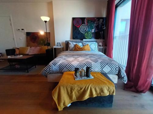 a bedroom with a bed with a yellow blanket at Gallery Home in Brussels