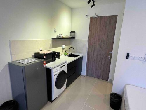 a small kitchen with a washing machine and a washer at THE SHORE KK CITY VIEW S15 By BC 亚比城市景观 in Kota Kinabalu