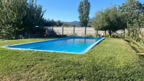 een blauw zwembad in het midden van een tuin bij Cabañas Reina Margarita in Santa Cruz