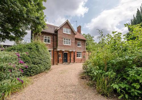 an old brick house with a garden in front of it at Gardeners Cottage - Nowton Park in Bury Saint Edmunds