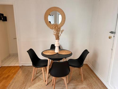 a table with chairs and a vase with a mirror at Chic Apartment on the famous shopping Rue du Faubourg Saint-Honoré street in Paris