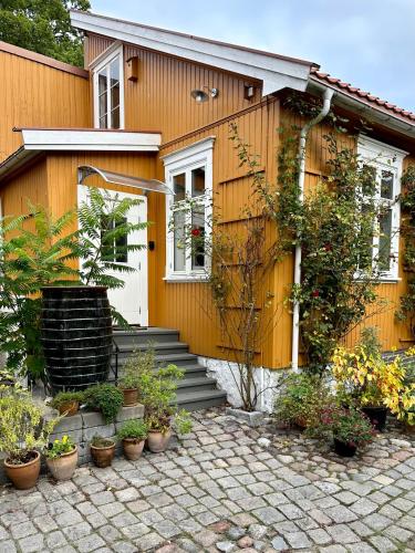 a yellow house with plants in front of it at Tollgaarden Gjestegaard in Larvik