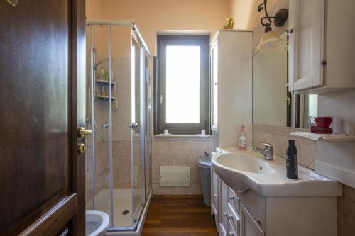 La salle de bains est pourvue d'un lavabo et d'une douche en verre. dans l'établissement L' uliveto, à San Piero Patti
