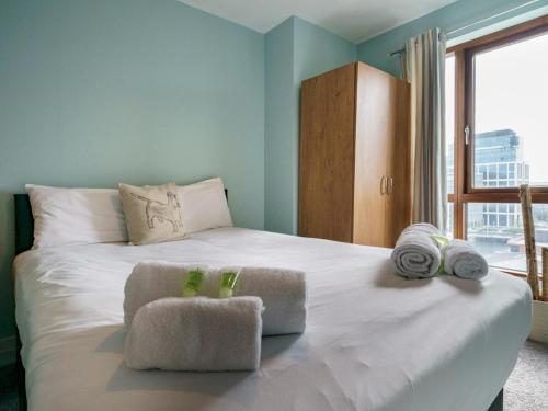 1 dormitorio con 1 cama blanca grande y toallas. en Pass the Keys Incredible Cityscape Views Balcony City Centre, en Belfast