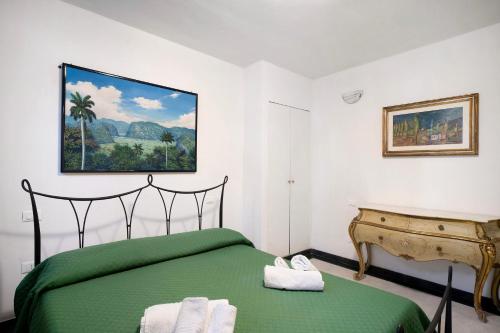 Un dormitorio con una cama verde y un piano en Le terme, borgo dei pescatori en Cervo