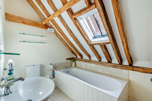 a bathroom with a bath tub and a sink at Court Lodge Oast in Heathfield