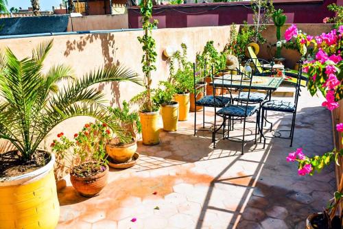 a patio with tables and chairs and potted plants at Dar Tuscia in Marrakech