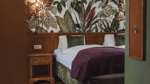 a bedroom with a bed with a wooden headboard and a table at Aparthotel Ansitz Felsenheim in Lermoos