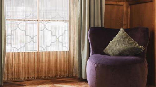 a pillow sitting on a chair in front of a window at Aparthotel Ansitz Felsenheim in Lermoos
