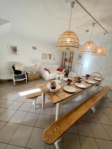 - un salon avec une table et deux lampes pendant dans l'établissement Gîte Brin de Nature au cœur de la nature bugiste, à Ambérieu-en-Bugey