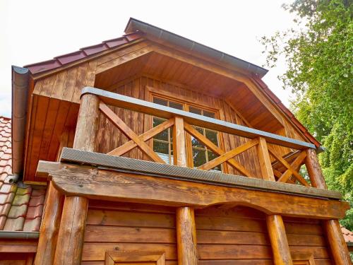 a balcony on the side of a wooden cabin at Strandschlösschen Sellin - House Half 3 in Ostseebad Sellin