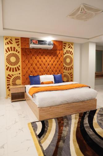 a bedroom with a bed with a wooden headboard at Nüva Hotel in Islamabad