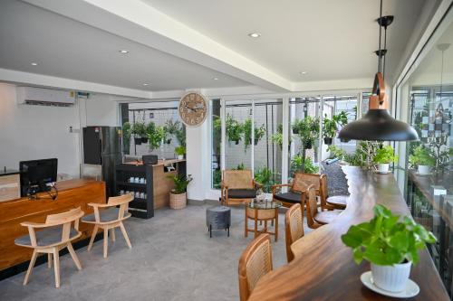 un soggiorno con bar, tavoli e sedie di Sivana Place Phuket a Bang Tao Beach