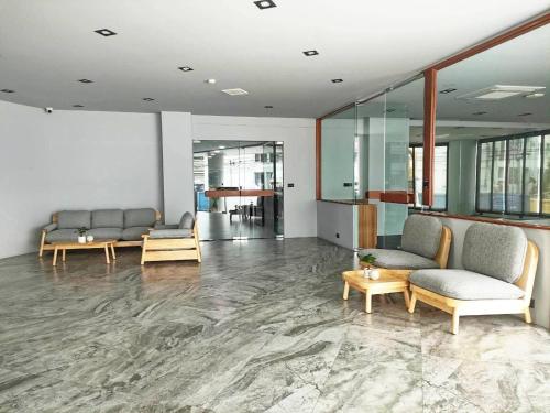 a lobby with couches and tables in a building at Tassanaplace Boutique Hotel (ฺBansuan) in Chon Buri