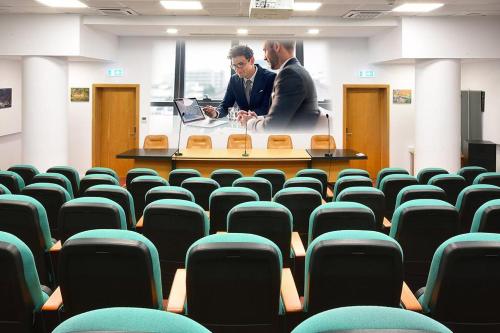 two men in a room with chairs and a table at COMPLEX PANORAMIC in Slănic-Moldova