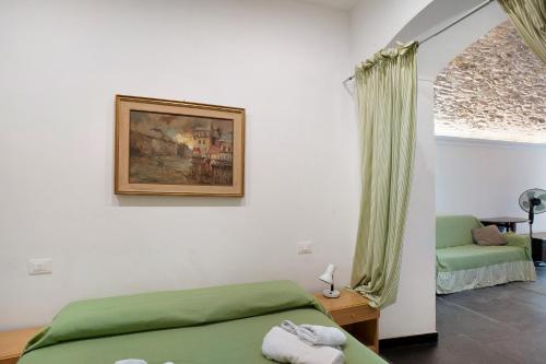 a bedroom with a green bed and a painting on the wall at Primo mare, borgo dei pescatori in Cervo