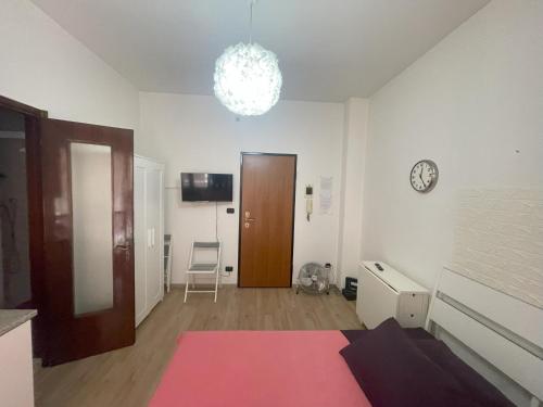 Una sala de estar con una alfombra rosa y un reloj. en Casa Vacanza Torino, en Turín