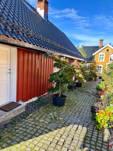 a courtyard with a red fence and a tree at Tollgaarden Gjestegaard in Larvik