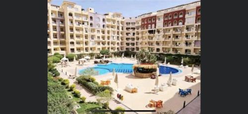 Binishty hurghada apartment في الغردقة: عمارة سكنية كبيرة بها مسبح كبير