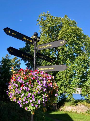 a street sign with signs on it with flowers at Tollgaarden Gjestegaard in Larvik