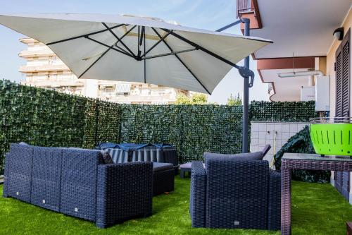 a patio with chairs and an umbrella on the grass at EMMEA8 APARTMENTS RELAX in Angri