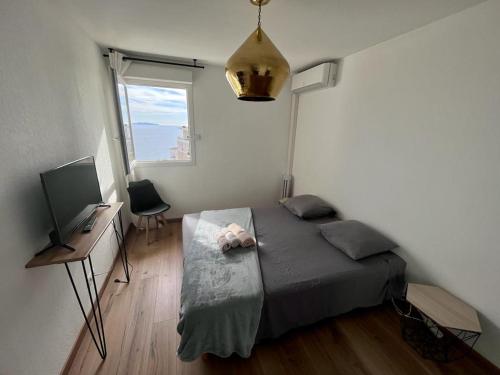 une chambre avec un lit, un bureau et une télévision dans l'établissement CAPO FENO AJACCIO, à Ajaccio