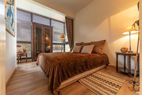 une chambre avec un grand lit et une grande fenêtre dans l'établissement Appartement Nael - LES GETS, en plein centre et au pied des pistes, aux Gets