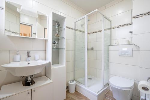 La salle de bains blanche est pourvue d'un lavabo et d'une douche. dans l'établissement Private Apartment, à Hanovre