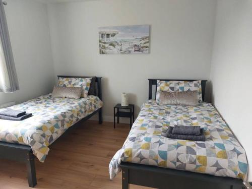dwa łóżka siedzące obok siebie w sypialni w obiekcie Stunning New 3 Bed Townhouse w mieście Belmullet